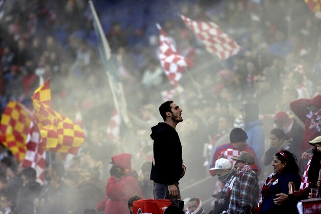 A New York Red Bulls supporter leads the the crowd during chants during the second half of an MLS soccer match against the Columbus Crew, Sunday, Oct. 19, 2014, in Harrison, N.J. (AP Photo/Julio Cortez)