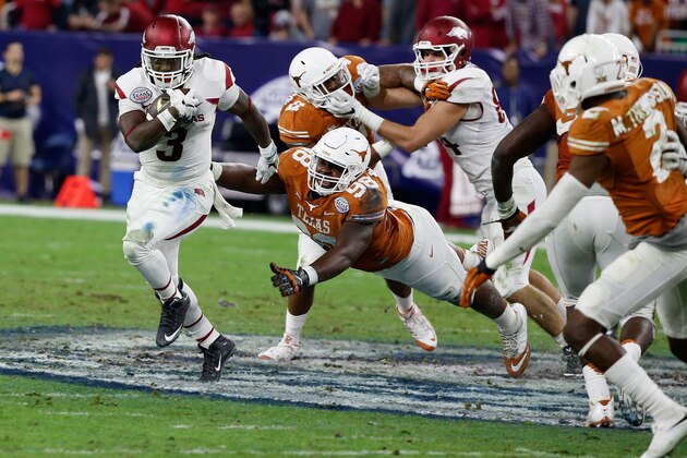HOUSTON, TX - DECEMBER 29:  Alex Collins #3 of the Arkansas Razorbacks runs away from Hassan Ridgeway #98 of the Texas Longhorns in the first half of their game at the AdvoCare V100 Texas Bowl at NRG Stadium on December 29, 2014 in Houston, Texas.  (Photo by Scott Halleran/Getty Images)