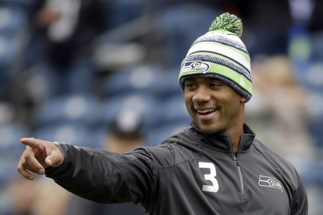 FILE - In this Nov. 2, 2014, file photo, Seattle Seahawks quarterback Russell Wilson smiles as he warms up on the field before an NFL football game against the Oakland Raiders in Seattle. The Seahawks will take on the Green Bay Packers in the NFC Championship game on Sunday, Jan. 18, in Seattle. (AP Photo/Elaine Thompson, File)