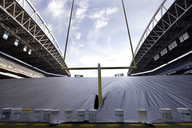 A giant tarp covers the artificial playing surface at the Seattle Seahawks' field, CenturyLink Field, Thursday, Jan. 8, 2015, in preparation for Saturday's NFL football divisional playoff game between the Seahawks and the Carolina Panthers in Seattle. The tarp, resembling a massive pillow as fans blowing from underneath lift it up to several stories high, is protecting and allowing newly-painted logos and field markings underneath to dry. (AP Photo/Elaine Thompson)