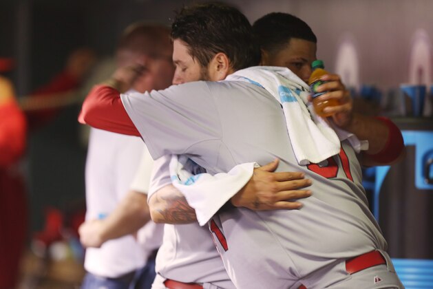 St. Louis Cardinals starting pitcher Lance Lynn, front, hugs catcher Yadier Molina after Lynn retired the Colorado Rockies in the eighth inning of the Cardinals' 8-0 victory in a baseball game in Denver on Monday, June 23, 2014. Lynn earned his eighth win of the season. (AP Photo/David Zalubowski)