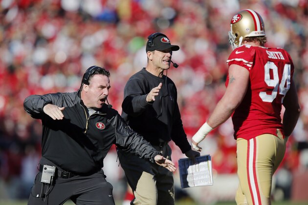 SAN FRANCISCO, CA - DECEMBER 08:  Defensive line coach Jim Tomsula  and head coach Jim Harbaugh congratulate defensive tackle Justin Smith #94 of the San Francisco 49ers after a sack on quarterback Russell Wilson of the Seattle Seahawks for a loss of nine yards in the first quarter on December 8, 2013 at Candlestick Park in San Francisco, California.  The 49ers won 19-17.  (Photo by Brian Bahr/Getty Images)