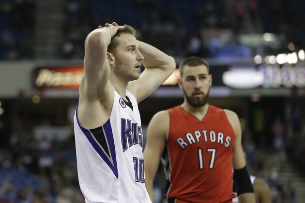 Sacramento Kings guard Nik Stauskas, of Canada, puts his hands on his head after being called for a foul during the third quarter of an NBA preseason basketball game against the Toronto Raptors in Sacramento, Calif., Tuesday, Oct. 7, 2014. The Kings won 113-106.   At right is Raptors center Jonas Valanciunas, of Lithuania.(AP Photo/Rich Pedroncelli)