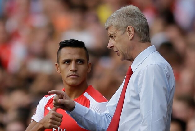Arsenal's French manager Arsene Wenger, right, gives instructions to his new signing Alexis Sanchez as he substituted on to make his debut, during the Emirates Cup soccer match between between Arsenal and Benfica at Arsenal's Emirates Stadium in London, Saturday, Aug. 2, 2014.  (AP Photo/Matt Dunham)