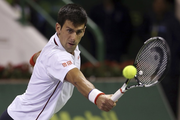 Novak Djokovic of Serbia returns the ball against Croatia's Ivo Karlovic during their quarterfinal of the Qatar Open at the Khalifa tennis complex in Doha, Qatar, Thursday, Jan. 8, 2015. (AP Photo/Osama Faisal)