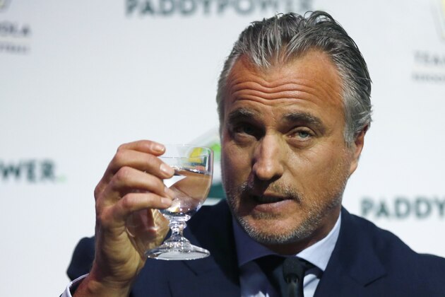 Former France soccer player David Ginola holds up a glass at a press conference to launch his bid to challenge Sepp Blatter for the FIFA presidency, in London, Friday Jan. 16, 2015. 47-year-old Ginola has until Jan. 29 to show FIFA he has the support of five national associations, and he must also prove he has played an