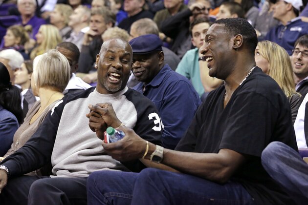 Former Seattle SuperSonics' player Gary Payton, left, and former teammate Shawn Kemp share a laugh on the sidelines as the two watch their sons, Gary Payton II, of Oregon State, and Shawn Kemp Jr., of Washington, in the first half of an NCAA college basketball game Thursday, Jan. 15, 2015, in Seattle.(AP Photo/Elaine Thompson)