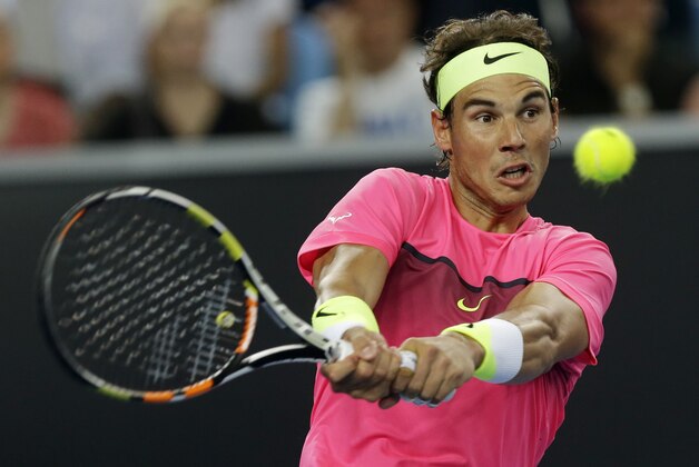 Spain's Rafael Nadal plays a backhand return to Australia's Mark Philippoussis during an exhibition match on Margaret Court Arena ahead of the Australian Open tennis championship in Melbourne, Australia, Wednesday, Jan. 14, 2015. The opening Grand Slam event of the year begins here on Monday January 19.  (AP Photo/Mark Baker)