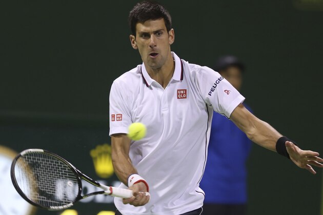 Novak Djokovic of Serbia returns the ball against Croatia's Ivo Karlovic during their quarterfinal of the Qatar Open at the Khalifa tennis complex in Doha, Qatar, Thursday, Jan. 8, 2015. (AP Photo/Osama Faisal)