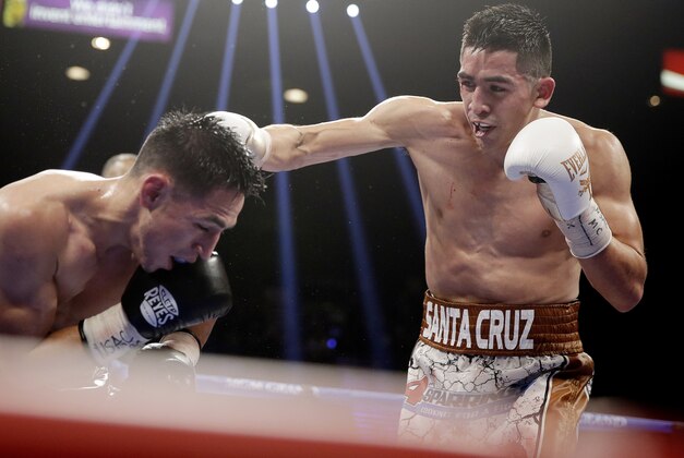 Leo Santa Cruz, right, punches Jesus Ruiz during their WBC super bantamweight championship boxing bout Saturday, Jan. 17, 2015, in Las Vegas. Santa Cruz won the fight when it was stopped in the eighth round. (AP Photo/Isaac Brekken)