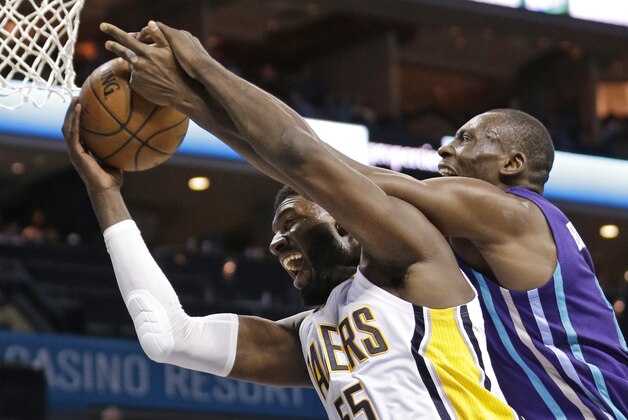 Indiana Pacers' Roy Hibbert, left, is fouled by Charlotte Hornets' Bismack Biyombo, right, during the second half of an NBA basketball game in Charlotte, N.C., Saturday, Jan. 17, 2015. The Hornets won 80-71 in overtime. (AP Photo/Chuck Burton)