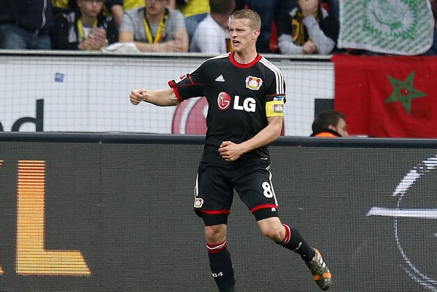 Leverkusen's Lars Bender celebrates his side's opening goal during a German Bundesliga soccer match between Bayer 04 Leverkusen and Borussia Dortmund in Leverkusen, Germany, Saturday, April 26, 2014. (AP Photo/Michael Probst)