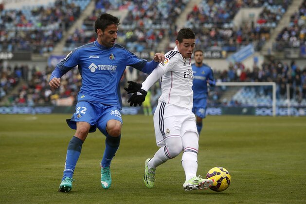 Real Madrid's James Rodriguez, right, in action with Getafe’s Juan Rodríguez, left, during a Spanish La Liga soccer match between Getafe and Real Madrid at the Coliseum Alfonso Perez stadium in Madrid, Spain, Sunday, Jan. 18, 2015. (AP Photo/Andres Kudacki)