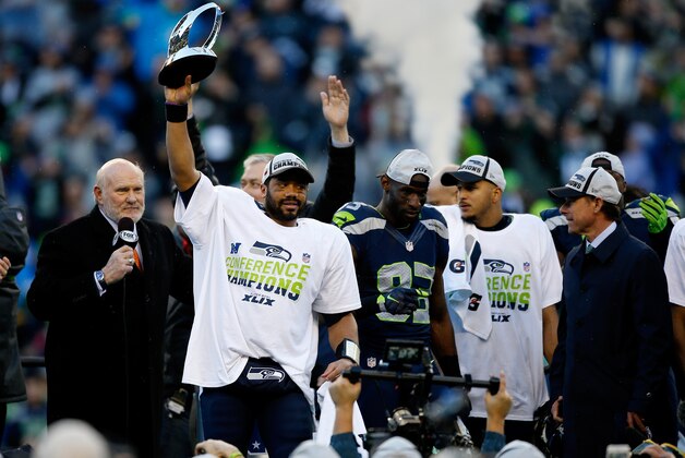 SEATTLE, WA - JANUARY 18:  Russell Wilson #3 of the Seattle Seahawks holds up the George S. Halas trophy after the Seahawks 28-22 overtime victory against the Green Bay Packers in the 2015 NFC Championship game at CenturyLink Field on January 18, 2015 in Seattle, Washington.  (Photo by Otto Greule Jr/Getty Images)