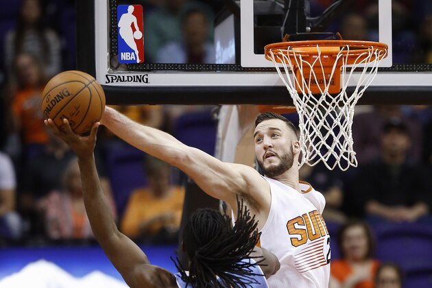 Phoenix Suns' Miles Plumlee, right, blocks the shot of Denver Nuggets' Kenneth Faried during the second half of an NBA basketball game Wednesday, Nov. 26, 2014, in Phoenix. The Suns defeated the Nuggets 120-112. (AP Photo/Ross D. Franklin)