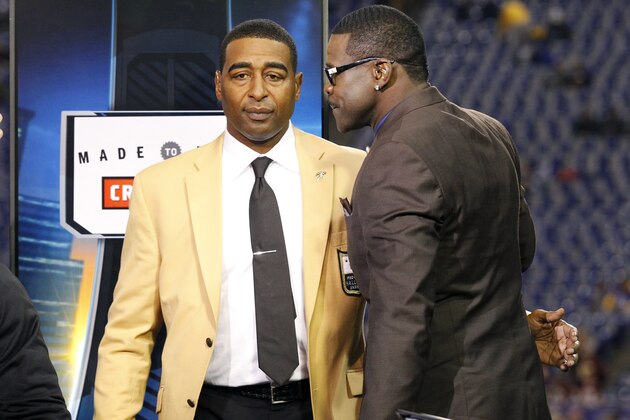 Former Minnesota Vikings wide receiver Cris Carter, left, talks with Thursday Night Football analyst Michael Irvin, right, before an NFL football game between the Minnesota Vikings and the Washington Redskins, Thursday, Nov. 7, 2013, in Minneapolis. (AP Photo/Ann Heisenfelt)