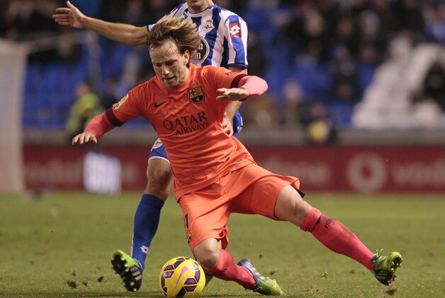 Barcelona's Ivan Rakitic, left, fights for the ball against Deportivo's Jose Rodriguez, during a Spanish La Liga soccer match at the Riazor stadium in A Coruna, Spain, Sunday, Jan. 18, 2015. (AP Photo/Lalo R. Villar)