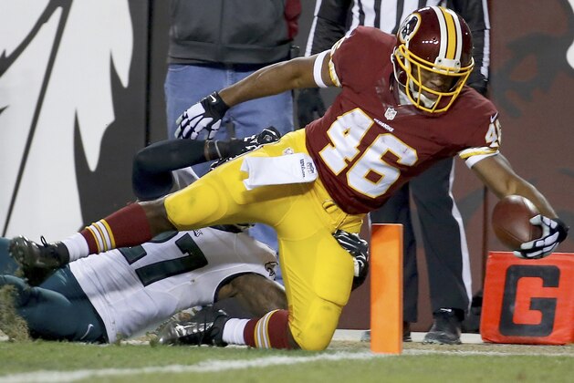 Washington Redskins running back Alfred Morris (46) dives into the end zone for a touchdown under pressure from Philadelphia Eagles free safety Malcolm Jenkins (27) during the first half of an NFL football game in Landover, Md., Saturday, Dec. 20, 2014. (AP Photo/Alex Brandon)