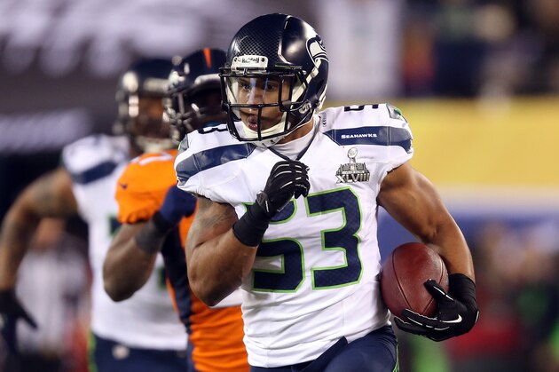 EAST RUTHERFORD, NJ - FEBRUARY 02:  Outside linebacker Malcolm Smith #53 of the Seattle Seahawks runs 69-yards for a touchdown against the Denver Broncos after intercepting a pass intended for running back Knowshon Moreno #27 of the Denver Broncos in the second quarter during Super Bowl XLVIII at MetLife Stadium on February 2, 2014 in East Rutherford, New Jersey.  (Photo by Jeff Gross/Getty Images)