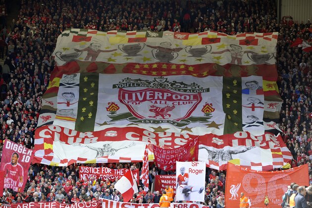 Liverpool fans hold aloft scarves & banners in the Kop end during the English Premier League soccer match between Liverpool and Manchester City at Anfield in Liverpool, England, Sunday April. 13, 2014. (AP Photo/Clint Hughes)