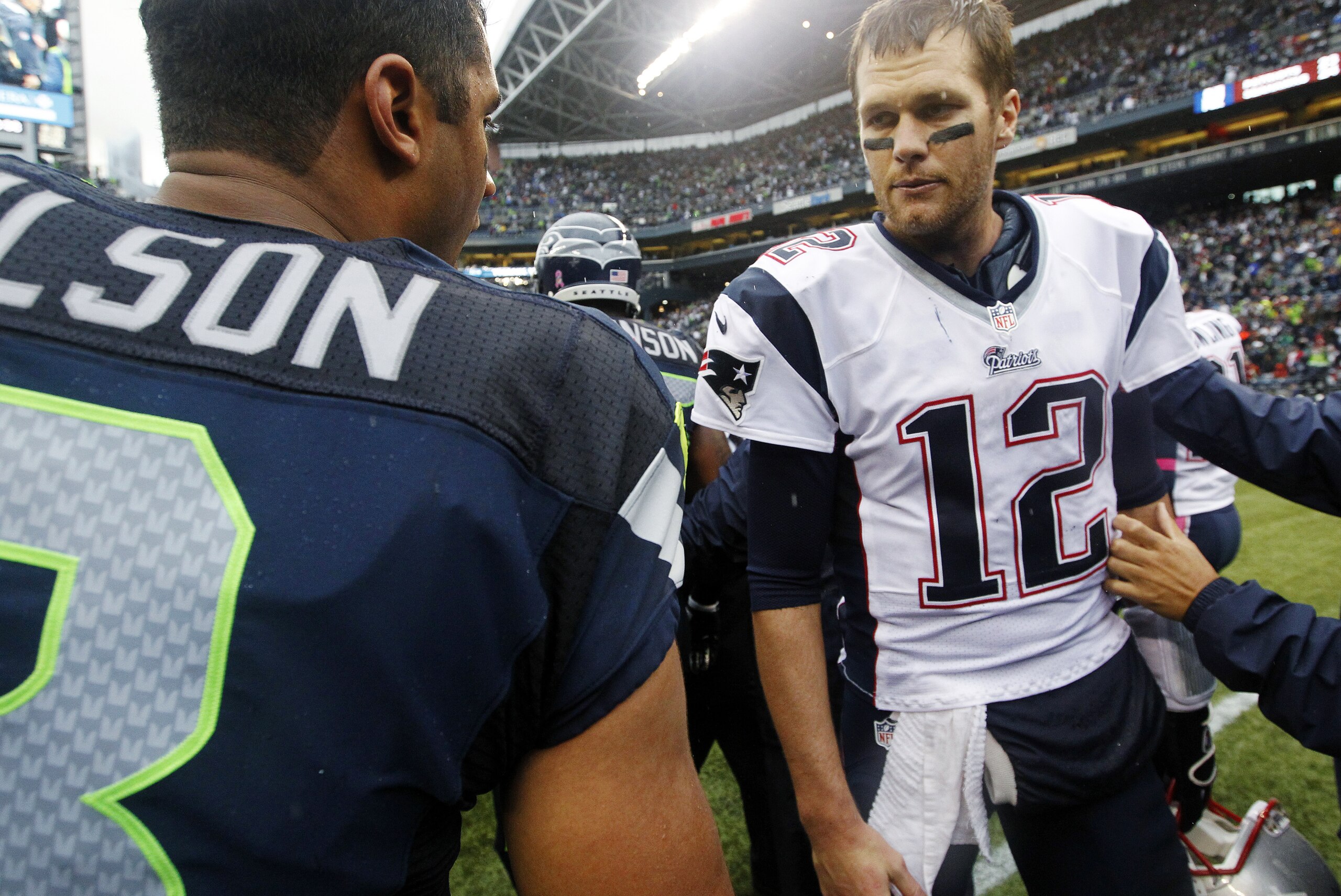 FILE - In this Oct. 14, 2012, file photo, New England Patriots quarterback Tom Brady (12) talks with Seattle Seahawks quarterback Russell Wilson after an NFL football game, in Seattle. There is a lot to look forward to when Wilson's Seahawks take on Brady's Patriots in the Super Bowl, and not just that Seattle can become the first team to win consecutive NFL championships since New England a decade ago. (AP Photo/Elaine Thompson, File)