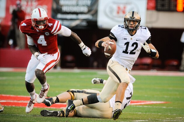 LINCOLN, NE - NOVEMBER 1: Quarterback Austin Appleby #12 of the Purdue Boilermakers runs from defensive end Randy Gregory #4 of the Nebraska Cornhuskers during their game at Memorial Stadium on November 1, 2014 in Lincoln, Nebraska. Nebraska defeated Purdue 35-14. (Photo by Eric Francis/Getty Images)