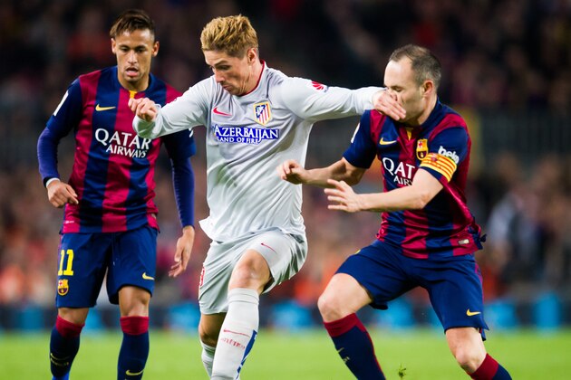 BARCELONA, SPAIN - JANUARY 11: Fernando Torres of Club Atletico de Madrid fights for the ball with Andres Iniesta of FC Barcelona during the La Liga match between FC Barcelona and Club Atletico de Madrid at Camp Nou on January 11, 2015 in Barcelona, Spain. (Photo by Alex Caparros/Getty Images)
