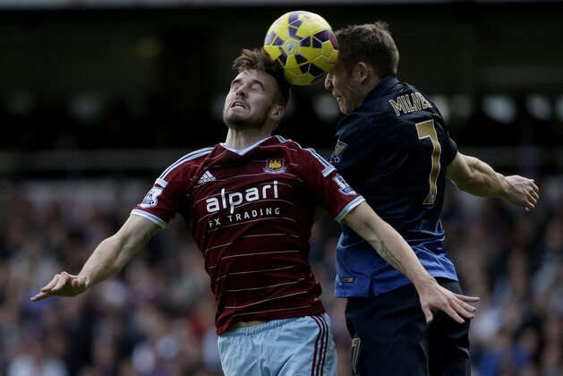 West Ham's Carl Jenkinson, left, competes for the ball with Manchester City's James Milner during the English Premier League soccer match between West Ham and Manchester City at Upton Park stadium in London, Saturday, Oct. 25, 2014. (AP Photo/Matt Dunham)