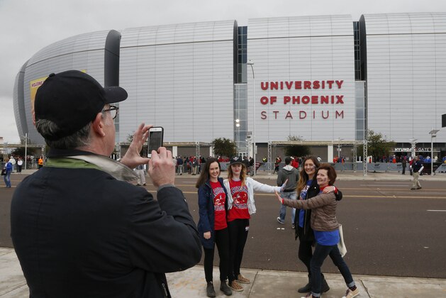Fan pose outside University of Phoenix Stadium prior to the Fiesta Bowl NCAA college football game between Boise State and Arizona, Wednesday, Dec. 31, 2014, in Glendale, Ariz. (AP Photo/Matt York)