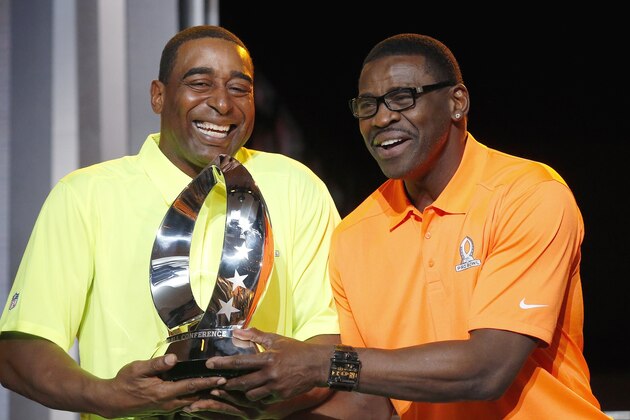 Michael Irvin, right, NFL Hall of Fame member and Pro Bowl Alumni captain, and Cris Carter, left, NFL Hall of Fame member and Pro Bowl Alumni captain, laugh as they playfully try to pull the Pro Bowl trophy away from one another during the Pro Bowl Kickoff news conference Tuesday, Jan. 20, 2015, in Phoenix.  The upcoming NFL Pro Bowl football game will be played on Sunday. (AP Photo/Ross D. Franklin)