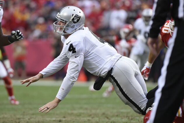 Oakland Raiders quarterback Derek Carr (4) is knocked down during the second half of their NFL football game against the Kansas City Chiefs in Kansas City, Mo., Sunday, Dec. 14, 2014. (AP Photo/Reed Hoffmann)