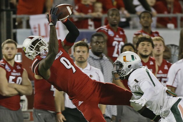 Louisville wide receiver DeVante Parker (9) catches a pass in front of Miami defensive back Artie Burns (1) during the second half of the Russell Athletic Bowl NCAA college football game in Orlando, Fla., Saturday, Dec. 28, 2013.(AP Photo/John Raoux)