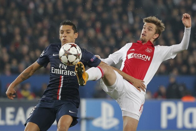 PSG's Marquinhos, left, challenges for the ball with Ajax's Lucas Andersen, right, during the Champions League Group F soccer match between Paris Saint Germain and Ajax at Parc des Princes stadium in Paris, France, Tuesday, Nov. 25, 2014. (AP Photo/Francois Mori)