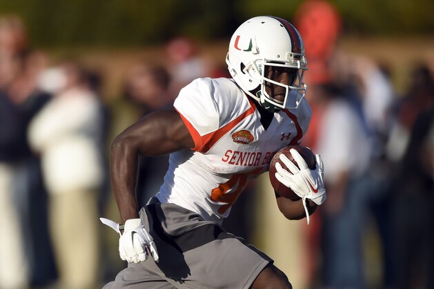Jan 20, 2015; Fairhope, AL, USA; South squad wide receiver Phillip Dorsett of Miami (4) carries the ball up the field South squad defensive corner JaCorey Shepherd of Kansas (24) during practice at Fairhope Stadium. Mandatory Credit: John David Mercer-USA TODAY Sports