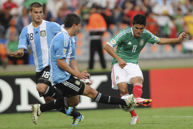 Argentina's Leandro Gonzalez Pirez, left, and teammate Hugo Nervo, center, battle for the ball with Mexico's Ulises Davila during a U-20 World Cup group F soccer match against Mexico in Medellin, Colombia, Friday, July 29, 2011. Argentina won 1-0.(AP Photo/Luis Benavides)