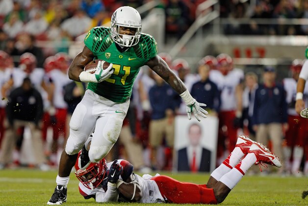 SANTA CLARA, CA - DECEMBER 5:  Running back Royce Freeman #21 of the Oregon Ducks escapes a tackle to take the ball to the five yard line against the Arizona Wildcats in the first quarter on December 5, 2014 during the Pac-12 Championship at Levi's Stadium in Santa Clara, California.  Oregon won 51-13.  (Photo by Brian Bahr/Getty Images)
