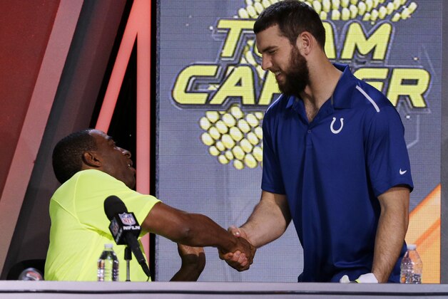 Cris Carter, left,  shakes hands with Indianapolis Colts' Andrew Luck after being picked during the Pro Bowl draft Wednesday, Jan. 21, 2015, in Phoenix. (AP Photo/David J. Phillip)