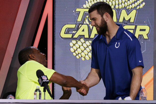 Cris Carter, left,  shakes hands with Indianapolis Colts' Andrew Luck after being picked during the Pro Bowl draft Wednesday, Jan. 21, 2015, in Phoenix. (AP Photo/David J. Phillip)