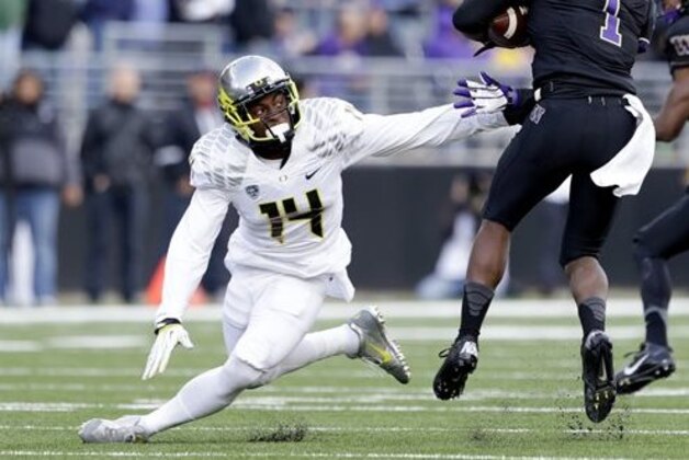 FILE - In this Oct. 12, 2013, file photo, Oregon's Ifo Ekpre-Olomu  defends against Washington in the second half of an NCAA college football game in Seattle. Ekpre-Olomu’s acrobatic interception against Michigan State perfectly illustrated his reason for staying at Oregon. The senior cornerback has more to prove with the Ducks. Oregon defeated the then-No. 7 Spartans 46-27 last Saturday, Sept. 6, 2014, pushing the Ducks up a spot in the AP Top 25 to No 2. (AP Photo/Elaine Thompson, File)