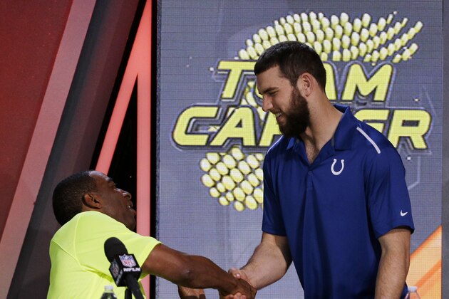Cris Carter, left,  shakes hands with Indianapolis Colts' Andrew Luck after being picked during the Pro Bowl draft Wednesday, Jan. 21, 2015, in Phoenix. (AP Photo/David J. Phillip)
