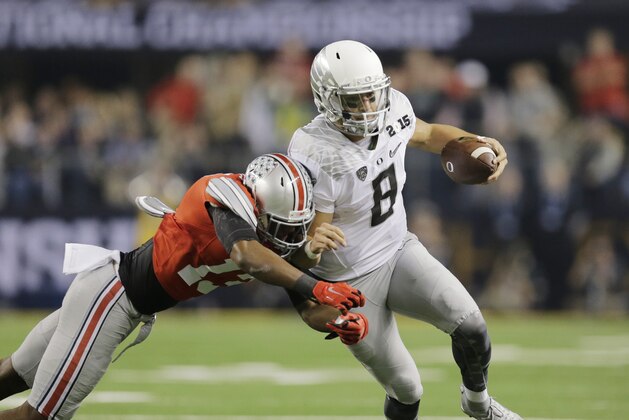 Oregon quarterback Marcus Mariota (8) is tackled by ]Ohio State cornerback Eli Apple (13) during the first half of the NCAA college football playoff championship game Monday, Jan. 12, 2015, in Arlington, Texas. (AP Photo/Eric Gay)
