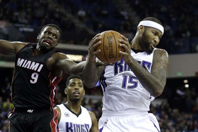 Sacramento Kings center DeMarcus Cousins,  right, pulls a rebound away from Miami Heat forward Luol Deng, left, of South Sudan, as Kings forward Jason Thompson looks on during the first quarter of an NBA basketball game in Sacramento, Calif., Friday, Jan. 16,  2015. (AP Photo/Rich Pedroncelli)