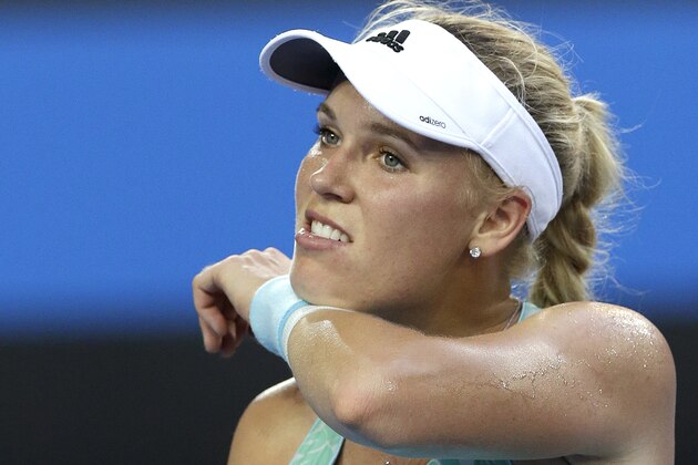 Caroline Wozniacki of Denmark wipes the sweat from her face as she plays Victoria Azarenka of Belarus during their second round match at the Australian Open tennis championship in Melbourne, Australia, Thursday, Jan. 22, 2015. (AP Photo/Lee Jin-man)