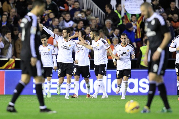 Valencia's Antonio Barragan, second left, celebrates after scoring against Real Madrid during a Spanish La Liga soccer match at the Mestalla stadium in Valencia, Spain, on Sunday, Jan. 4, 2015. (AP Photo/Alberto Saiz) is greeted by teammates