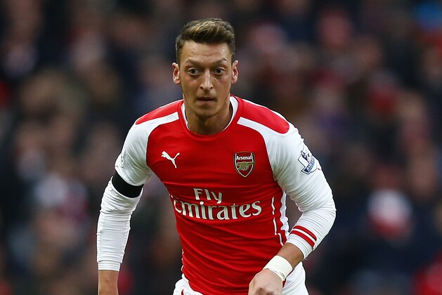 LONDON, ENGLAND - JANUARY 11:  Mesut Oezil of Arsenal runs with the ball during the Barclays Premier League match between Arsenal and Stoke City at Emirates Stadium on January 11, 2015 in London, England.  (Photo by Clive Rose/Getty Images)