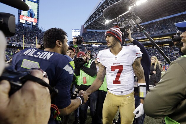San Francisco 49ers quarterback Colin Kaepernick (7) greets Seattle Seahawks quarterback Russell Wilson after an NFL football game, Sunday, Dec. 14, 2014, in Seattle. (AP Photo/Elaine Thompson)