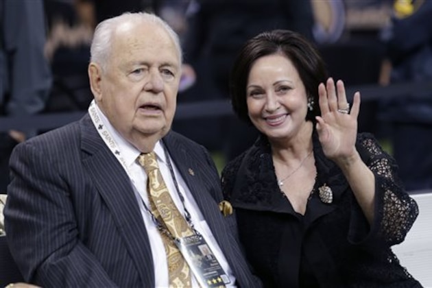 FILE - In this Oct. 26, 2014, file photo, New Orleans Saints owner Tom Benson sits on the sideline with his wife Gayle Benson before an NFL football game against the Green Bay Packers in New Orleans. Tom Benson, who owns the Saints and NBA's Pelicans, asserted in a statement released Thursday, Jan. 22, 2015,  that removing his daughter and grandchildren from the operation of his sports franchises _ and inserting his wife of 10 years in their place _ will ensure the clubs’ long-term stability and future in New Orleans. (AP Photo/Bill Haber, File)