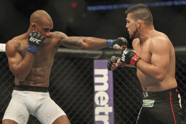 Jun 28, 2014; San Antonio, TX, USA; Kelvin Gastelum (red gloves) fights Nico Musoke (blue gloves) in a Welterweight bout at UFC Fight Night 43 at AT&T Center. Mandatory Credit: Troy Taormina-USA TODAY Sports