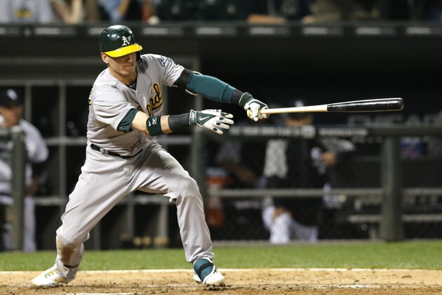 Oakland Athletics' Josh Donaldson hits a two-run single off Chicago White Sox relief pitcher Scott Snodgress, scoring Sam Fuld and Eric Sogard, during the ninth inning of a baseball game Tuesday, Sept. 9, 2014, in Chicago. The A's won 11-2. (AP Photo/Charles Rex Arbogast)