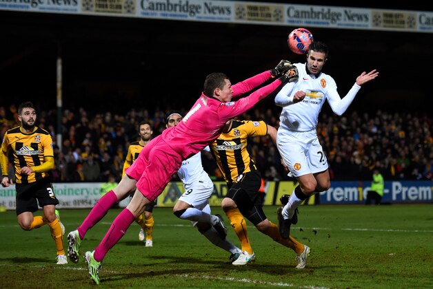 CAMBRIDGE, ENGLAND - JANUARY 23:  Chris Dunn of Cambridge United makes contact with Robin van Persie of Manchester United as he punches the ball clear during the FA Cup Fourth Round match between Cambridge United and Manchester United at The R Costings Abbey Stadium on January 23, 2015 in Cambridge, England.  (Photo by Shaun Botterill/Getty Images)